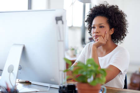 Keeping up to date with online developments. Beautiful creative professional looking intently at her...