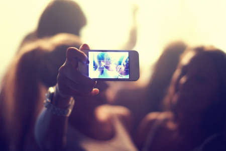 Well never forget this night. Shot of a fan filming a concert on their camera.の写真素材