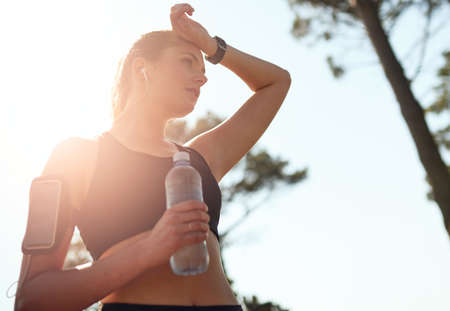 Know where youre going and get there. Shot of a fit young woman stopping for a drink of water during...