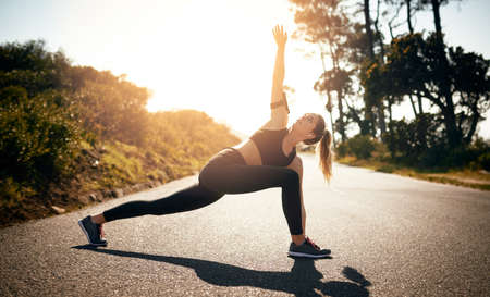 Getting her mind and muscles in the workout zone. Shot of a fit young woman stretching before a run...