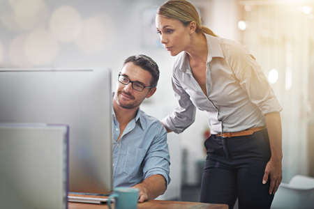 Shes always around to help. Cropped shot of two colleagues working together on a computer.