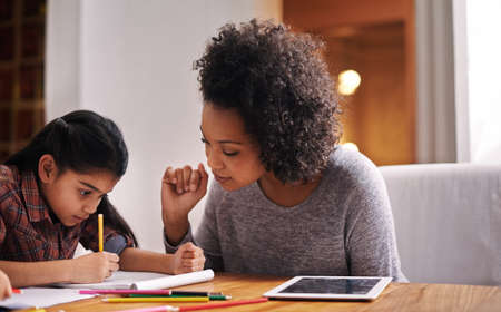 Looks like were done. Shot of a mother helping her daughter with her homework.