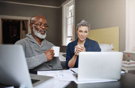 Taking control of their finances. Shot of a senior couple working on their finances at home.の写真素材