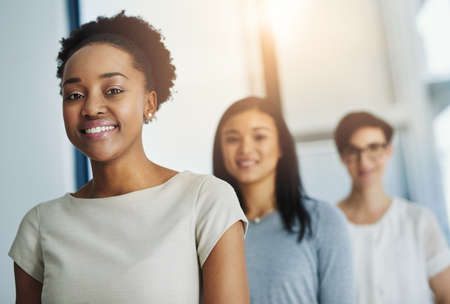 Showing the business world what theyre made of. Cropped shot of a group of businesspeople standing in the office.の写真素材