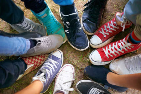 Express your individuality. A high-angle view of a group of people wearing sneakers and standing in a circle.の写真素材