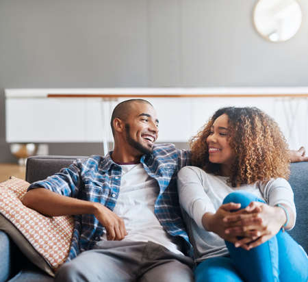 Im never too busy for my bae. Shot of a happy young couple relaxing together on the sofa at home.