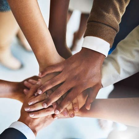 Teams dont work without teamwork. Cropped shot of a group of businesspeople piling their hands on...