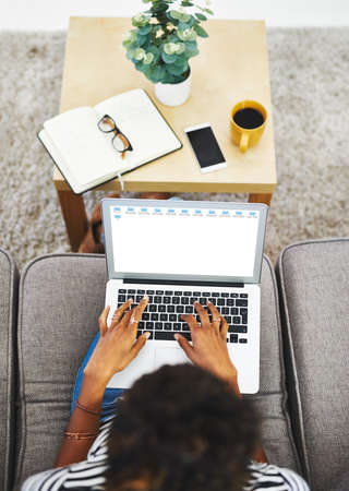 Trying to get work done at home. Shot of an unrecognizable woman working from home.