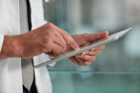 Tracking a patients progress. Closeup shot of an unrecognisable doctor using a digital tablet.の写真素材