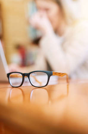 Your vision should be as clear as your future. Shot of a pair of glasses on a table indoors.の写真素材