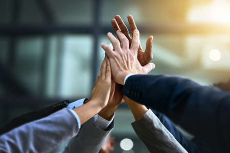 Turn good business into great business with teamwork. Cropped shot of a group of businesspeople joining their hands in solidarity.の写真素材