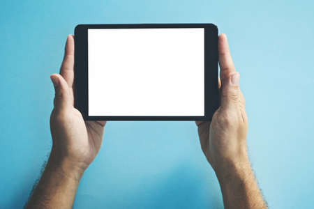 This website has been making waves online. Studio shot of a man holding a digital tablet with a blank screen against a blue background.の写真素材