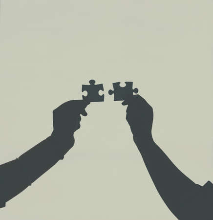 Finding that perfect fit. Defocussed shot of two unrecognizable businesspeople holding two puzzle...