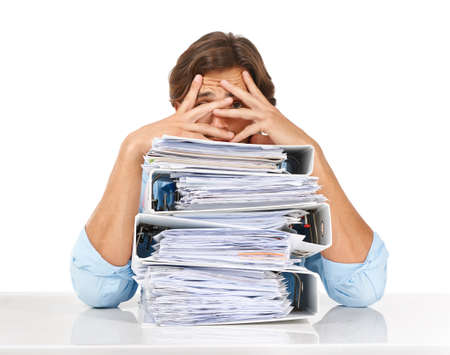 The paperwork just keeps piling up. Studio shot of a businessman sitting with a pile of files and...