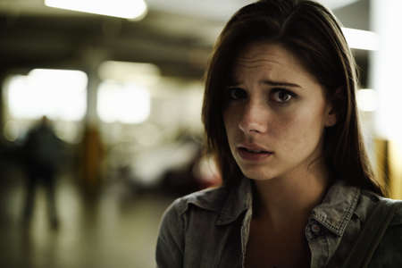 Feeling a twinge of fear. A terrified young woman in an underground parking garage being followed by...
