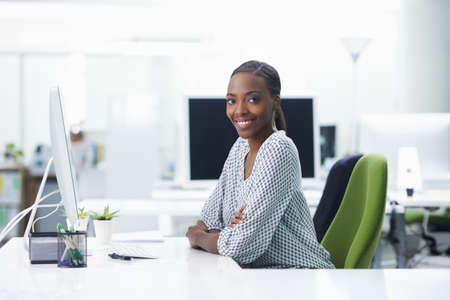 She finds her work very rewarding. Shot of a young businesswoman sitting at a desk.
