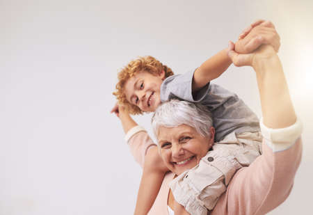 I have the best granny in the whole wide world. Shot of a grandmother giving her grandson a piggyback ride.の写真素材