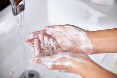 Good hygiene - a great habit. A cropped shot of a young woman washing her hands in her bathroom.