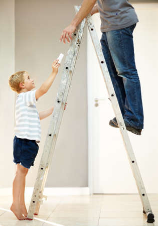 He loves assisting dad. Young boy helping his father with changing a lightbulb.の写真素材