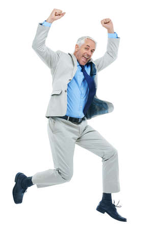 Business victory. Full length studio shot of a mature businessman jumping for joy isolated on white.の写真素材