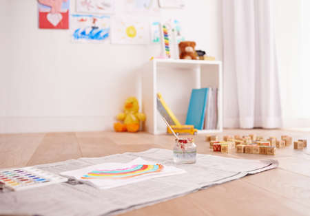 Ready to get creative. Shot of childrens painting supplies on the floor of a childs bedroom.の写真素材