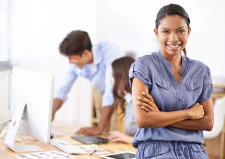 Shes a design expert. A gorgeous young retoucher with her colleagues in the background.