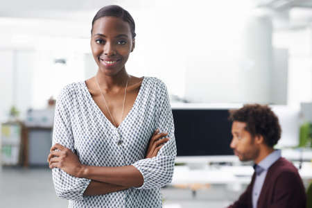 She always looks her best at work. Portrait of a young business woman standing with her arms...