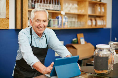 His service is always so welcoming. Shot of a senior man working in a coffee shop.