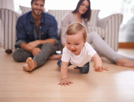 Meet the proud parents. Shot of a young married couple sitting at home with their baby.の写真素材