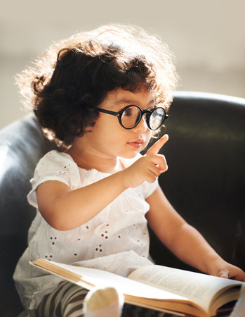 Learning as she grows. Shot of a cute little girl at home.の写真素材