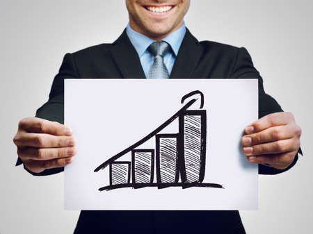The numbers are in. Cropped shot of a businessman holding up a hand-drawn profit graph.の写真素材