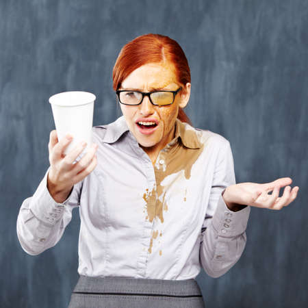 How did this even happen. A young redhead covered in coffee after an unfortunate spillage.の写真素材