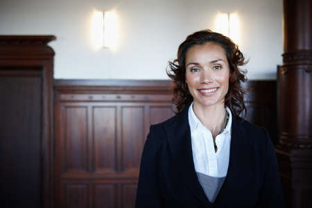 Cropped shot of an attractive mature female lawyer standing in a courtroom and smiling.
