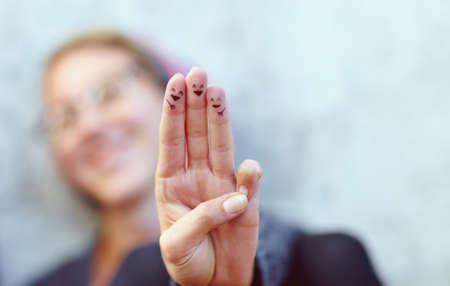 Smiles just for you. Cropped shot of fingers with smileys drawn on them.