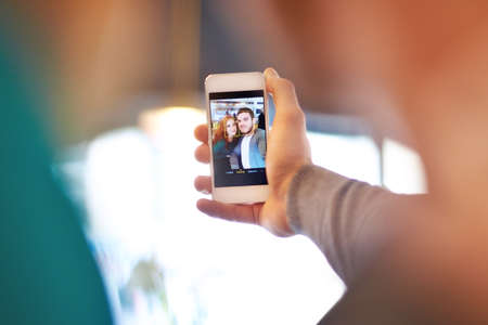 Sharing the moment. Shot of a young couple taking a photo of themselves while on a date at a cafe.の写真素材