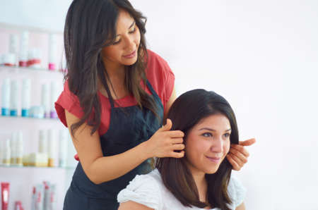 Styling by professionals you can trust. Cropped shot of an attractive young woman in the hair salon.の写真素材