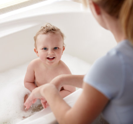 His favourite time of day. Cropped shot of a baby boy being bathed by his mother.