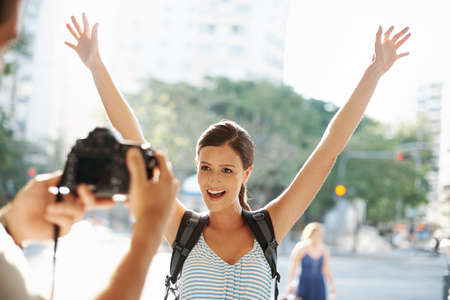 Excited about her vacation. Cropped shot of a young woman posing for a picture while traveling a foreign city.の写真素材