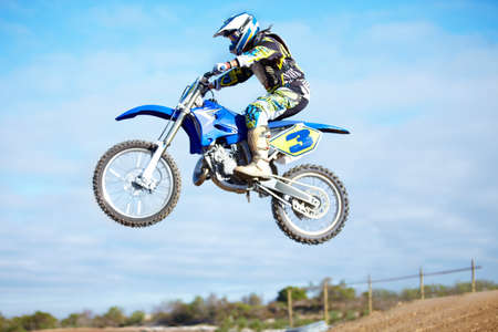 Hes a crowd pleaser. A motocross rider in the air during a jump.の写真素材