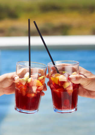 Heres to summer. Closeup of two friends toasting each other with their glasses.の写真素材