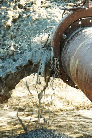 Pollution in the pipelines. Pipeline with polluted liquid gushing out of the pipe.の写真素材