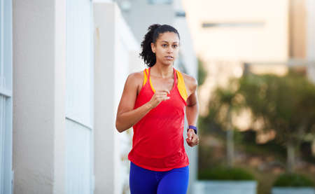 The decision is yours. Shot of a sporty young woman out running in the city by herself.の写真素材