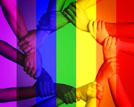 This is a discrimination free zone. Cropped shot of unrecognizable people linking arms against a...