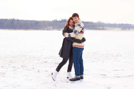 Winter romance. A young couple on an ice skating date at a frozen natural lake.の写真素材