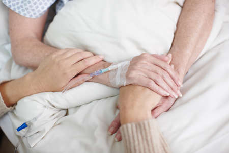 Comforting a sick family member. Cropped image of an affectionate daughters hand being held by her...
