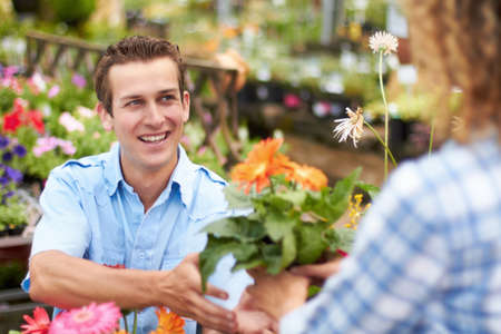 These will look great in our garden. A happy couple choosing flowers in a nursary.の写真素材