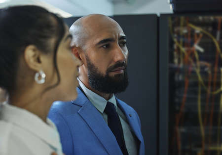 The final inspection. Shot of two young workers doing maintenance checks in a server room at work.