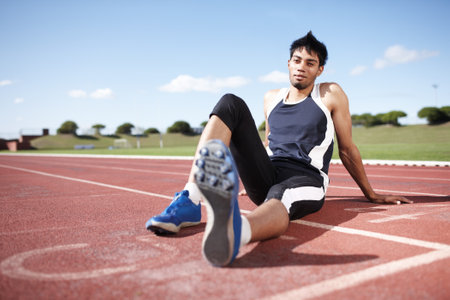 This is my turf. A young athlete leaning back on a running track.の写真素材