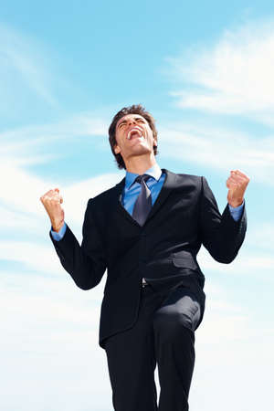 Victory- Successful business man with clenched fist against sky. Victory - Successful young business man with clenched fist against sky.の写真素材