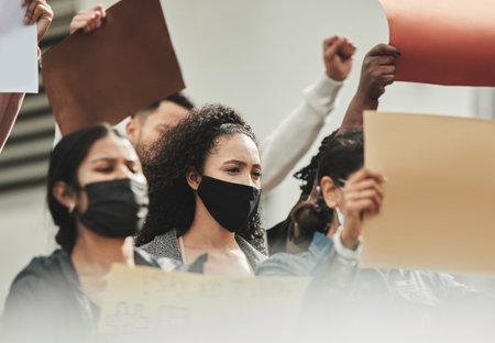 Its time to get involved. Low angle shot of a group of people holding signs while taking part in a political rally.の写真素材